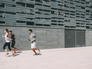 Fototapeta na wymiar three friends athletes jogging in a modern building district