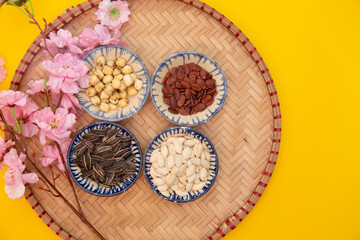 Tet Holiday, Lunar new year, chinese new year concept . Dried sunflower, lotus, watermelon and pumkin seeds top view isolated on yellow 