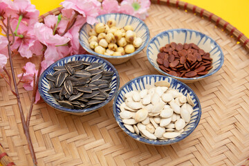 Tet Holiday, Lunar new year, chinese new year concept . Dried sunflower, lotus, watermelon and pumkin seeds top view isolated on yellow 