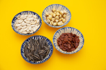 Tet Holiday, Lunar new year, chinese new year concept . Dried sunflower, lotus, watermelon and pumkin seeds top view isolated on yellow 
