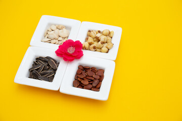 Tet Holiday, Lunar new year, chinese new year concept . Dried sunflower, lotus, watermelon and pumkin seeds top view isolated on yellow 