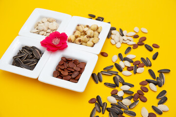 Tet Holiday, Lunar new year, chinese new year concept . Dried sunflower, lotus, watermelon and pumkin seeds top view isolated on yellow 