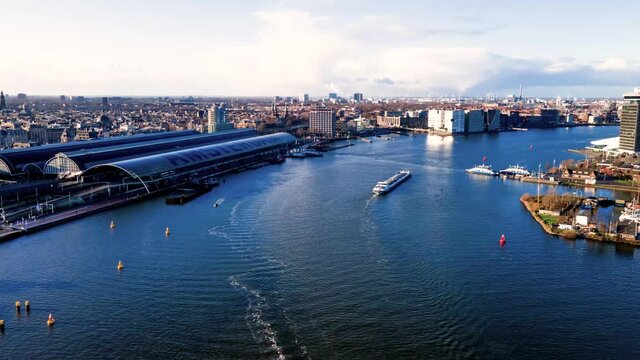 Amsterdam Central Aerial view timelapse hyperlapse, the city center in Amsterdam and the Ij river, The Netherlands ferries and public transport fly over drone shot.