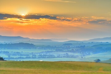 DRAKENSBERG FOOTHILLS IN THE DAWN.  Summer sunrise over farmlands, district Underberg, Kwazulu Natal, South Africa