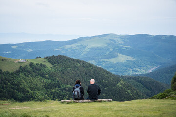 un couple de randonneurs assis &agrave; la montagne. Des gens  touristes regardant le paysage de montagne. Des gens contemplant la montagne