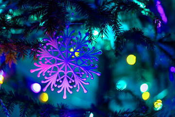 Obraz na płótnie Canvas blue lilac snowflake on a Christmas tree at night blue lighting with lanterns, horizontal format