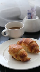 Croissants on white plate and Black Coffee. Breakfast. Pastries.