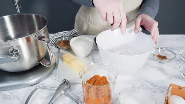 Time lapse. Mixing ingredients in electric kitchen mixer to bake pumpkin spice cupcake.