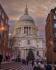 tourists and Christmas tree in front of St Paul's cathedral under impressive sky, London UK