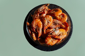Shrimps in a transparent bowl on an olive background.  King Prawns Olive Gray Background. Plate King Prawns Top View