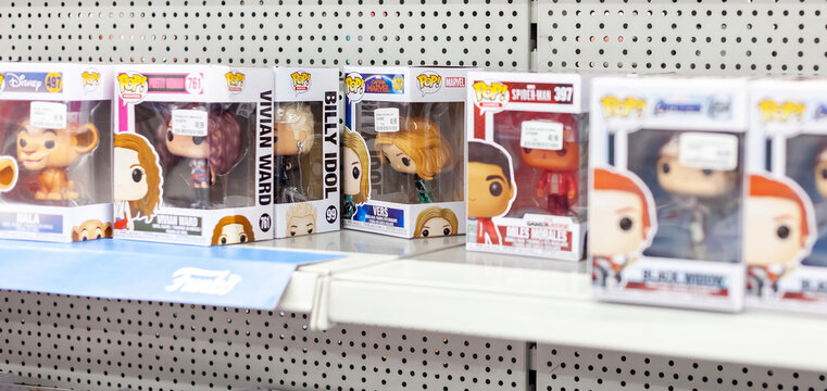 Lots of Funko Pop figurines packed in boxes in a row on a shop display, shallow depth of field. Collectibles retail, pop culture products, fandom designs