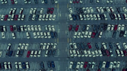 Cinematic drone straight down shot of organised and clean minimalistic and symmetrical industrial car park. Cars parked at factory manufacturing location, airport or big shopping mall
