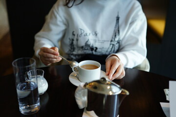 Obraz na płótnie Canvas カフェでミルクティーを飲む女性