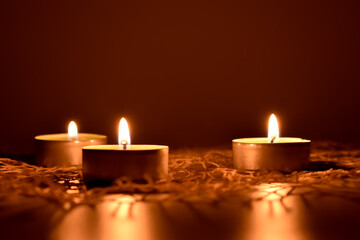 Trzy małe świeczki na jasnej serwetce.