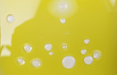 Puddle of water and drops in natural olive oil background, top view