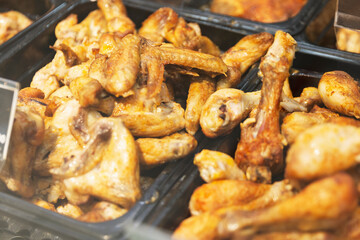 Grilled chicken wings and legs on the counter in the store. Close-up. Selective focus.