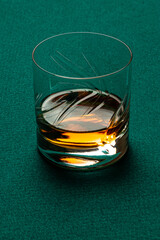 Glass of Whiskey without ice on a casino mat.