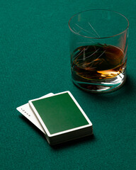 Green poker deck on top of a casino mat revealing the Joker.
