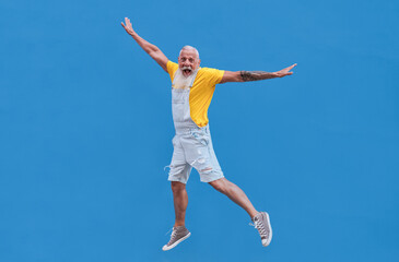Fototapeta na wymiar Crazy hipster senior man jumping outdoor - Joyful elderly generation concept