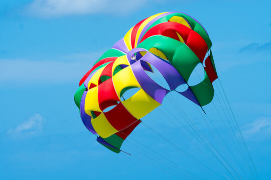 parachute in the sky which is open belonging to parasailing recreational activity concept Summer fun