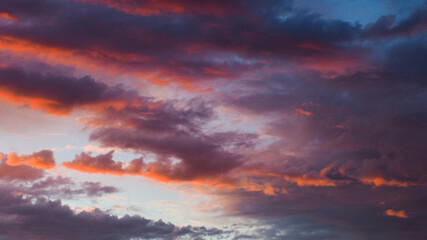 Magnifiques teintes rougeoyantes sous des nuages de moyenne altitude, pendant le coucher du soleil.  Le temps est instable