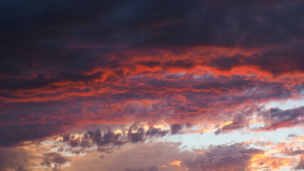 Magnifiques teintes rougeoyantes sous des nuages de moyenne altitude, pendant le coucher du soleil.  Le temps est instable