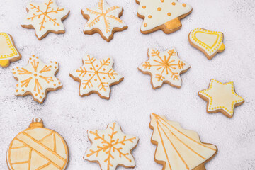 Fototapeta na wymiar Homemade Christmas gingerbread cookies on white background.Cookies of various shapes in sugar glaze. Snowflake, star, bell, ball, Christmas tree.