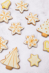 Fototapeta na wymiar Homemade Christmas gingerbread cookies on white background.Cookies of various shapes in sugar glaze. Snowflake, star, bell, Christmas tree.