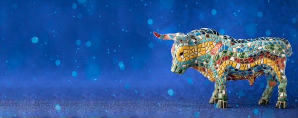 Obraz na płótnie Canvas Multicolored bull on a blue shiny New Year's card background