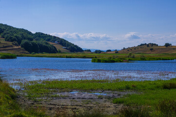 Fototapeta na wymiar View of the hill, reeds and lake.