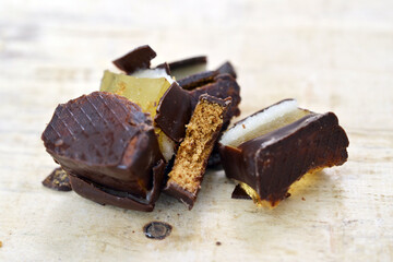 filled chocolate marzipan cubes close up ,sweet food on wood background