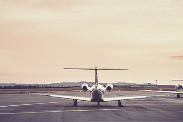 Private airplane parked at the airport at sunset.