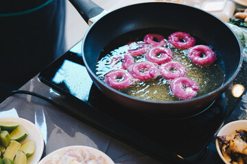 frying purple sweet potato doughnut. deep fried dessert