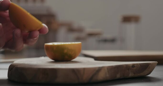 Slow motion man scoop lulo fruit with a spoon on olive wood board with copy space
