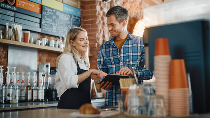 Two Diverse Entrepreneurs Have a Team Meeting in Their Stylish Coffee Shop. Barista and Cafe Owner...