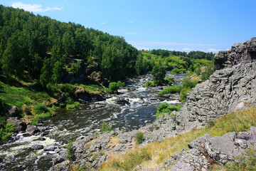 Fototapeta na wymiar Mountain river flowing in stone gorge