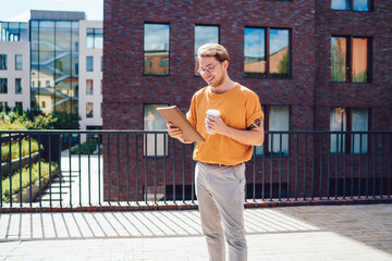 Cheerful student reading notebook on street