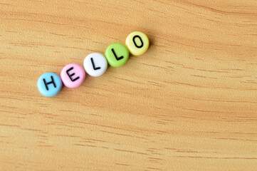 Selective focus with blurred effect of colorful alphabet beads with text HELLO over wooden background.  © TeacherPhoto
