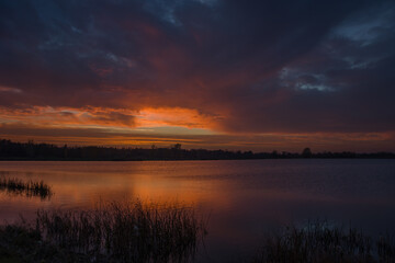 Fototapeta na wymiar Wonderful colorful clouds during sunset over the lake