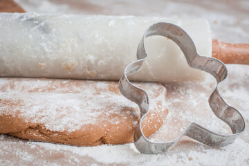 The process of baking cookies at home, closeup on cookie cutter on dough and rolling pin