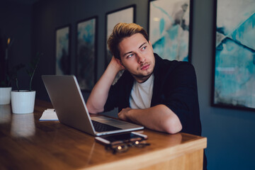 Thoughtful guy with laptop in office