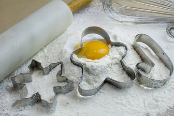 The process of baking cookies at home, closeup on cookie cutter on dough and rolling pin