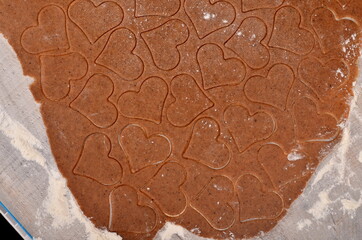 Flat rolled Raw dough for cooking Christmas cookies with ginger heart and other shapes, top view,...