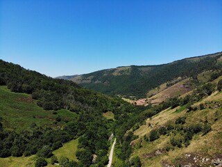 Fototapeta na wymiar Aerial view of beautiful mountains full of trees and vegetation in the north of Spain on a sunny day