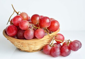 Red grape in an old basket on white background