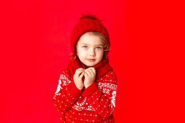 little girl in winter clothes on a red background. New year's concept