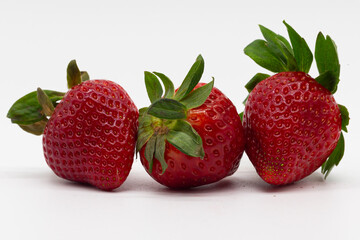 Red strawberries with green stem on white background. Fresh fruit. Healthy food