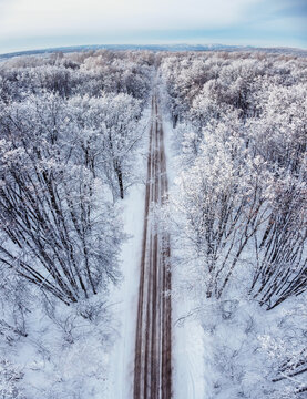 aerial landcape view, empty gravel road in snow covered winter forest, Russia, Samara