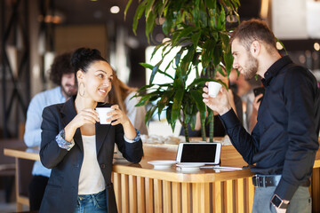 Friends at a cafe having coffee and chatting. Successful young people.