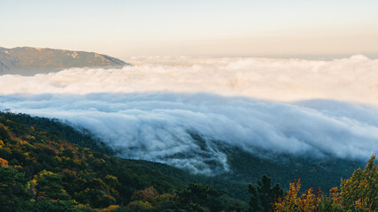 Fototapeta na wymiar View above the clouds in the mountains of Crimea in the area of Ai-Petri - one of the highest mountains of Crimea and a tourist attraction. Stunning panorama of the natural view